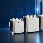 Three AC contactors of increasing frame size on an industrial control panel background
